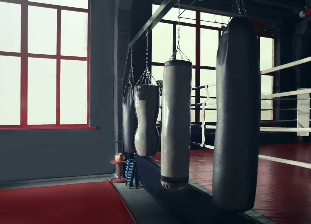 A boxing ring with several punching bags.