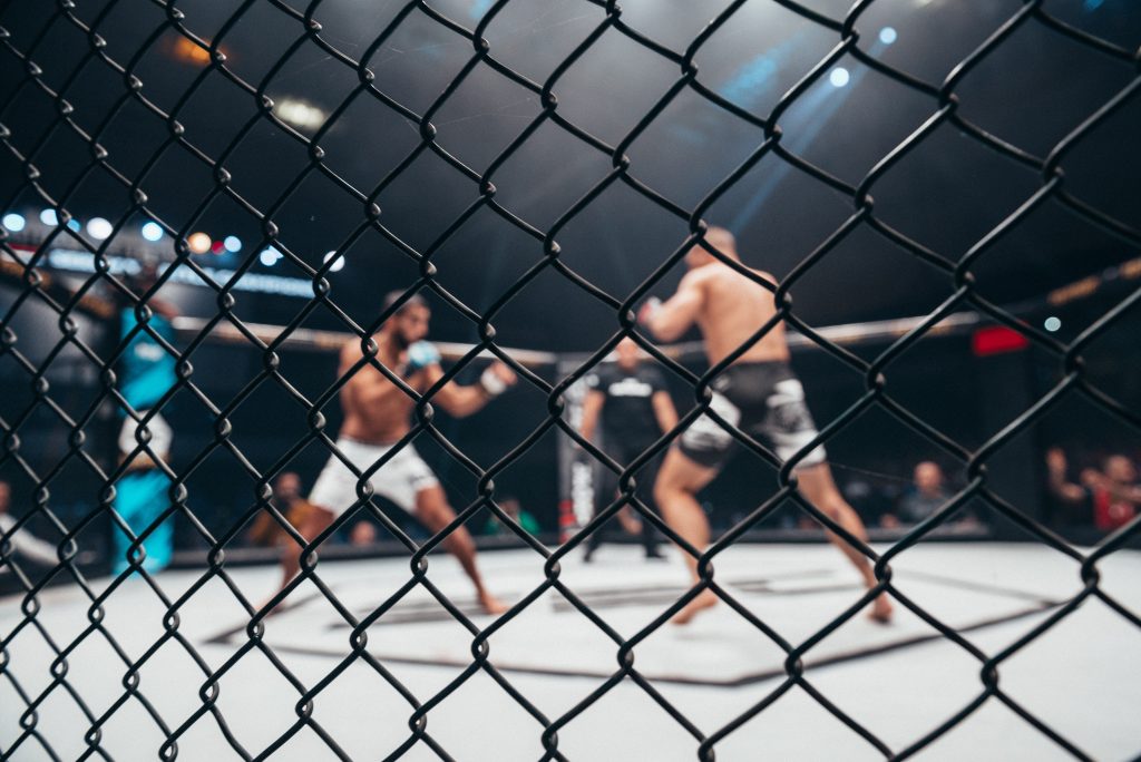 MMA fighters in cage at a boxing match.