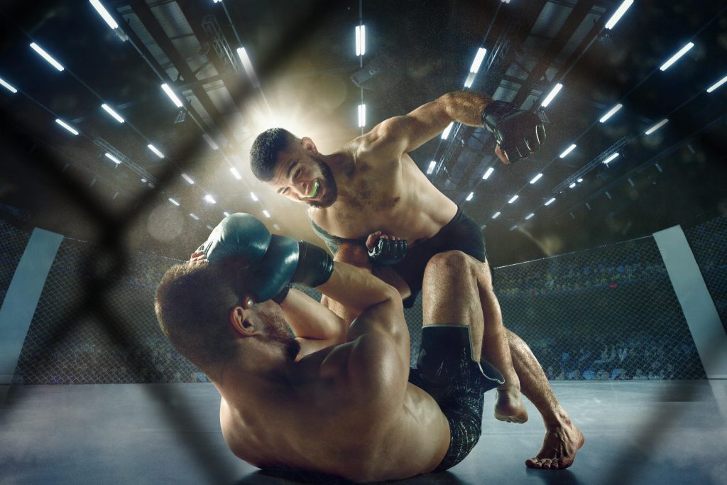 Two mma fighters fighting in a cage.