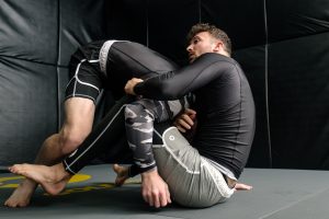 Two men are wrestling in a black room
