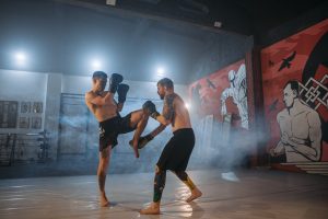 Two men practicing muay thai in a gym.