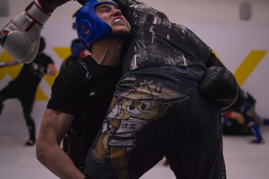 A man is fighting with another man in a boxing ring.