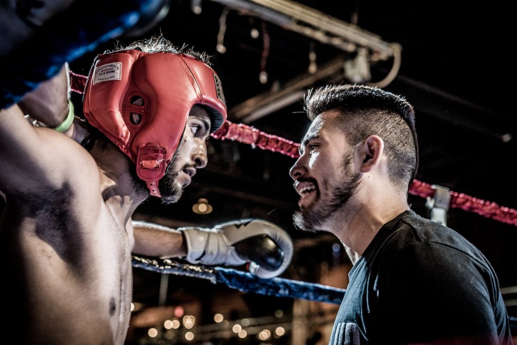 Two boxers talking in a boxing ring.