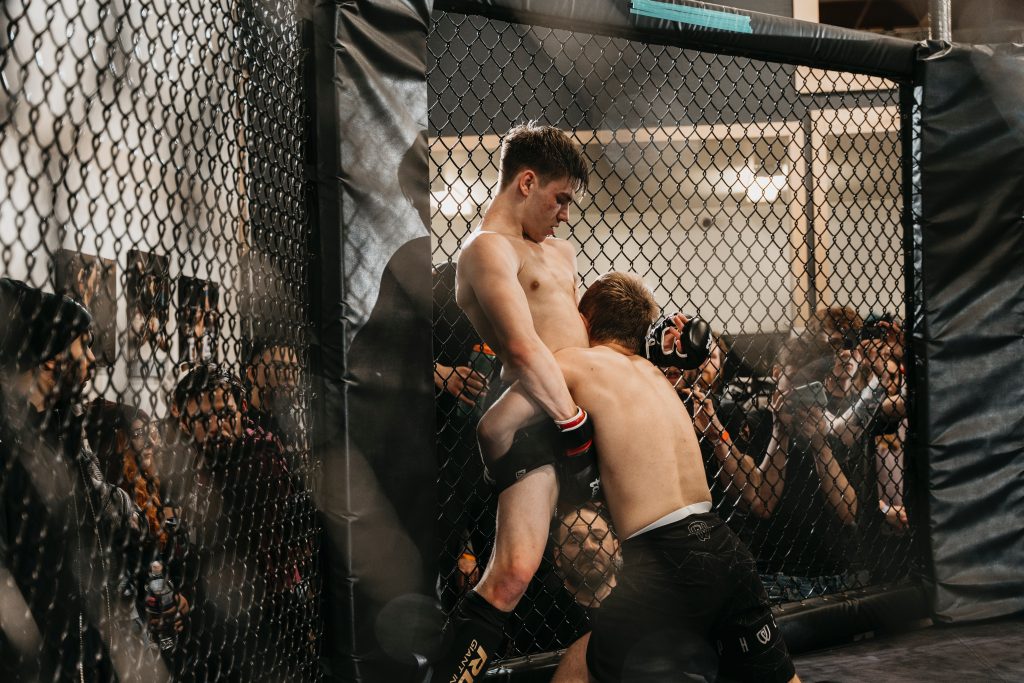 Two men fighting in an mma cage.