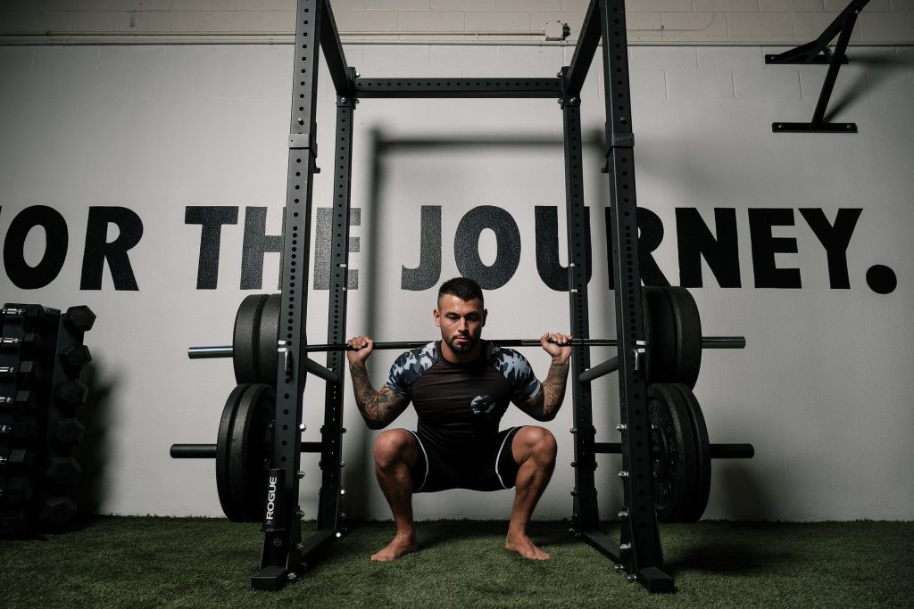 A man squats in front of a wall with the words for the journey.