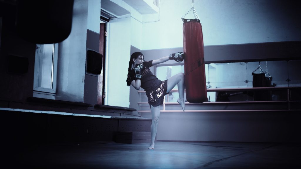 A man kicking a kick with a punching bag